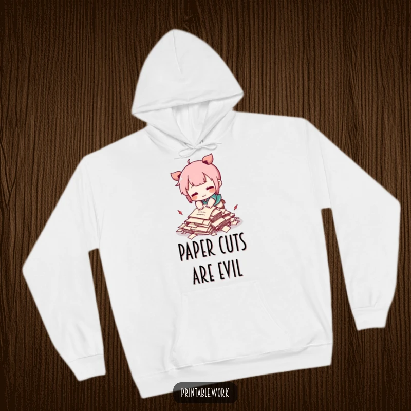 Funny Kawaii character comically tripping over a tiny pile of papers on a cozy hoodie, adorable and humorous.